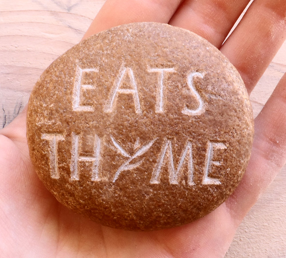 Logo de l'épicerie et restaurant libanais Eats Thyme gravé dans un galet