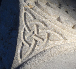Entrelac celtique gravé sur un angle de chapiteau en calcaire tendre