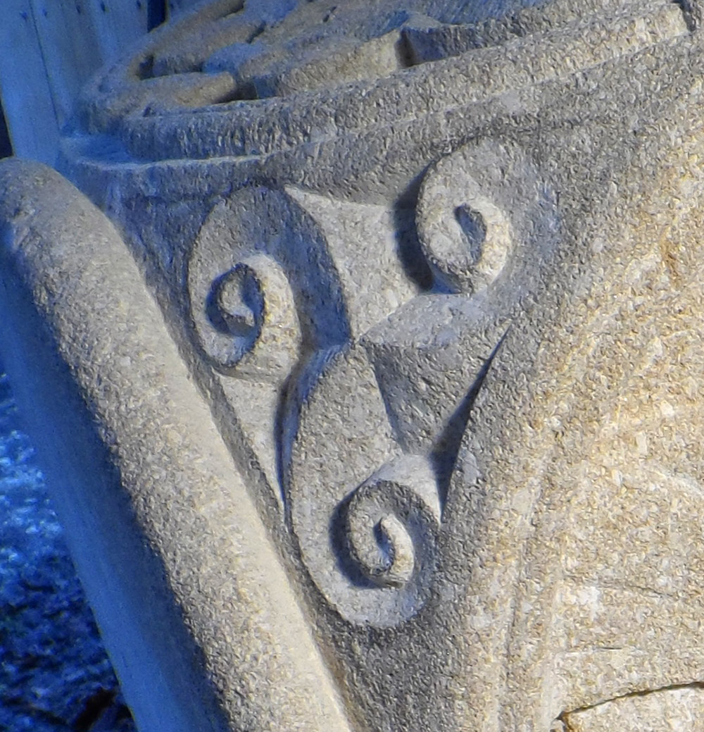 Triscèle gravé sur un angle de chapiteau en calcaire tendre