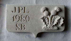 Plaque funéraire en savonnière : chardon lorrain en bas-relief et lettres romaines gravées
