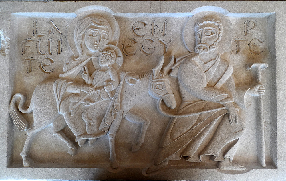 bas-relief en st maximin représentant la scène de la fuite en Egypte. Le nom de la scène est gravé en fond. Joseph marche, Marie et l'enfant Jésus sont sur un âne.