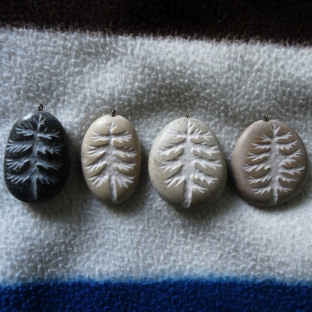 4 pendentifs faits à partir de galets avec un sapin gravé, terminés et posés
